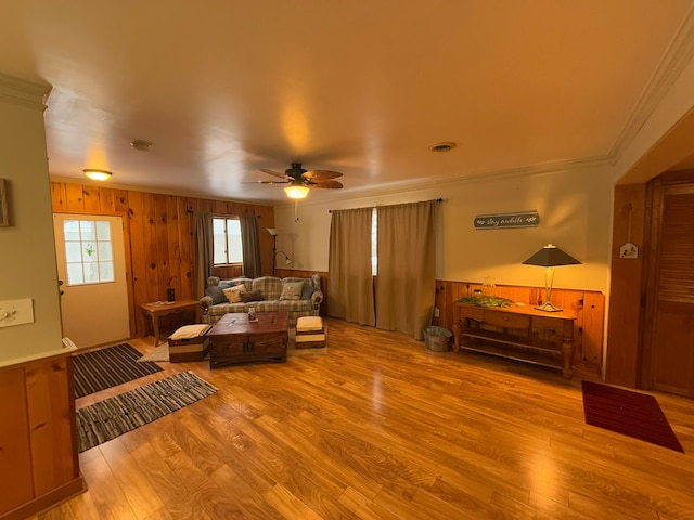 living room featuring crown molding, ceiling fan, and light wood-type flooring