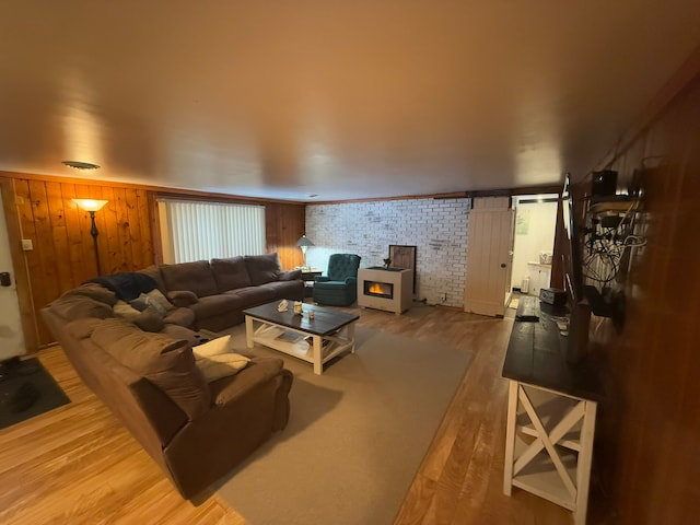 living room with wood-type flooring and brick wall