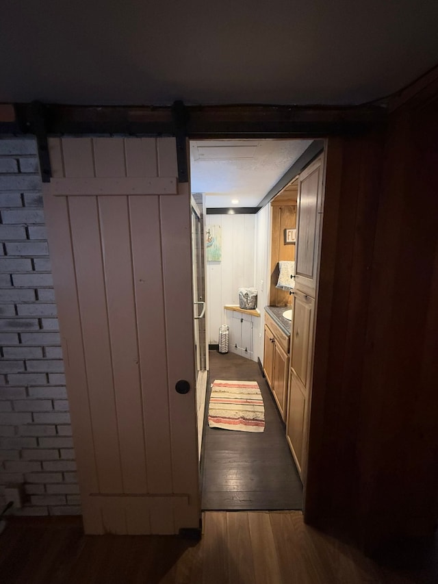 interior space with a barn door and dark hardwood / wood-style flooring