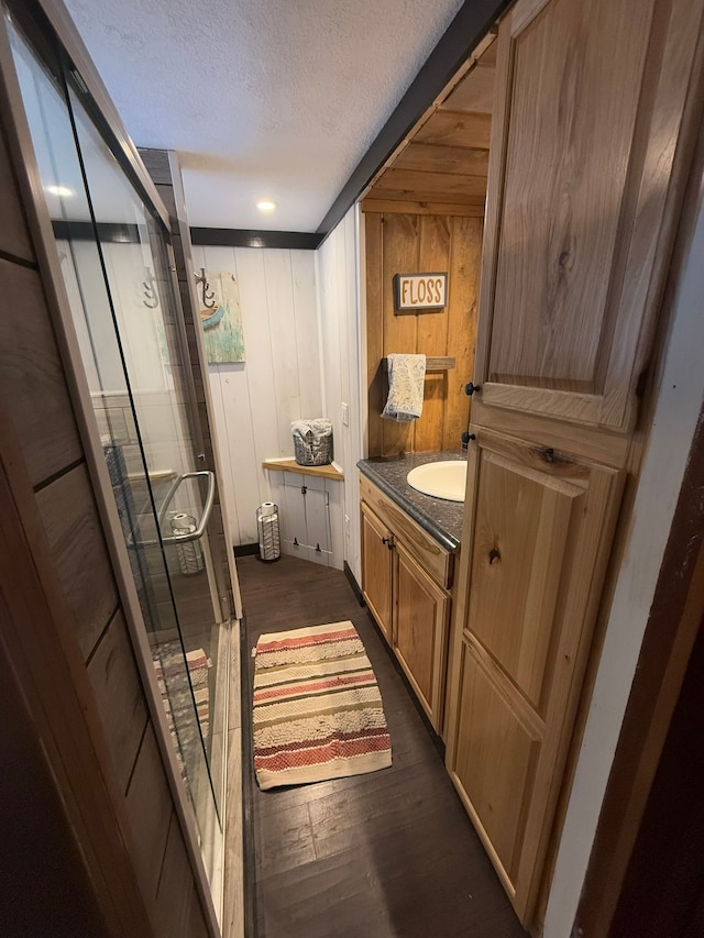 bathroom with hardwood / wood-style flooring, vanity, and a textured ceiling