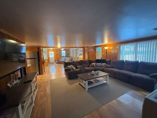 living room with wood walls and light wood-type flooring