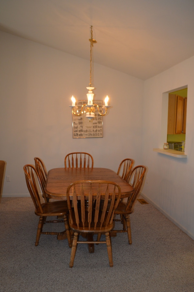 dining space with carpet floors and an inviting chandelier