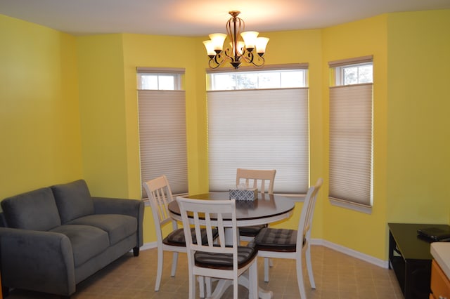 dining space with light tile patterned floors and an inviting chandelier