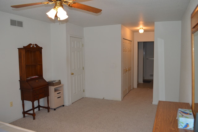 interior space featuring ceiling fan and light carpet