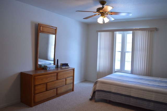 bedroom with ceiling fan and light carpet