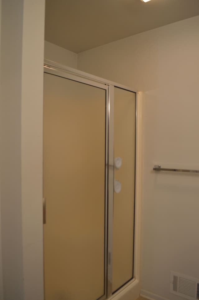 bathroom with a shower with door