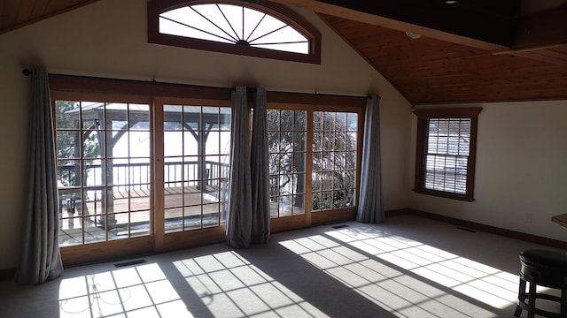 entryway featuring vaulted ceiling, a healthy amount of sunlight, wood ceiling, and carpet flooring