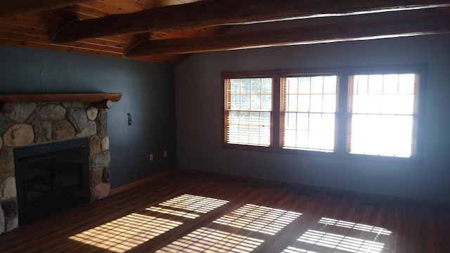 unfurnished living room with wood ceiling, a stone fireplace, dark wood-type flooring, and lofted ceiling with beams