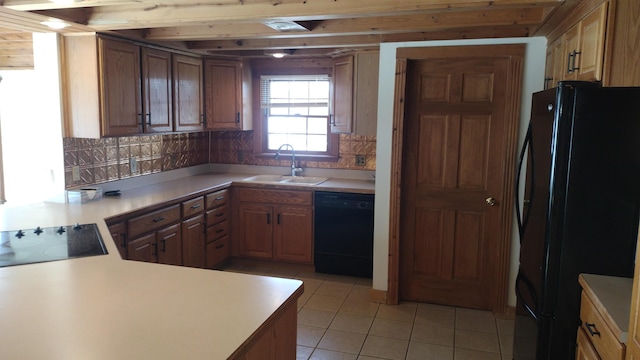 kitchen featuring light tile patterned flooring, black appliances, sink, decorative backsplash, and kitchen peninsula