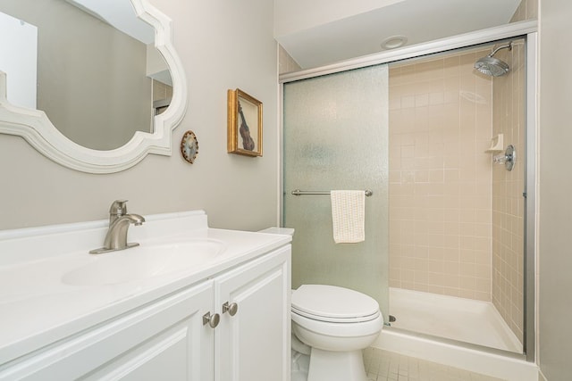 bathroom featuring vanity, a shower with door, and toilet