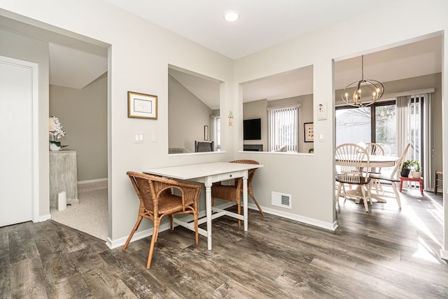 dining area featuring a notable chandelier and dark hardwood / wood-style floors