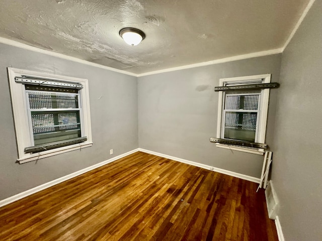 unfurnished room with wood-type flooring, crown molding, and a textured ceiling