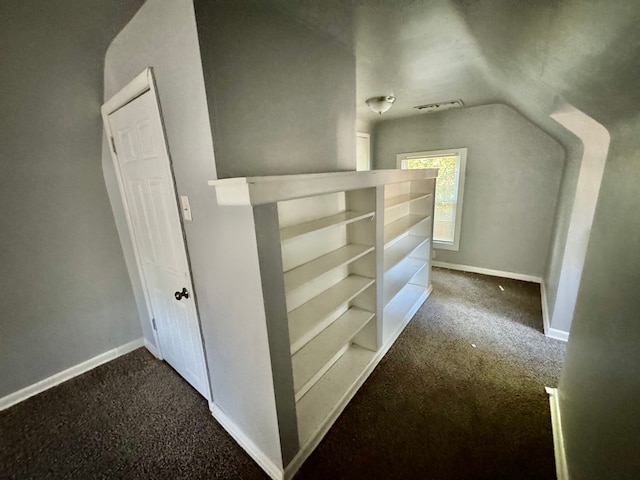 bonus room featuring lofted ceiling and dark carpet