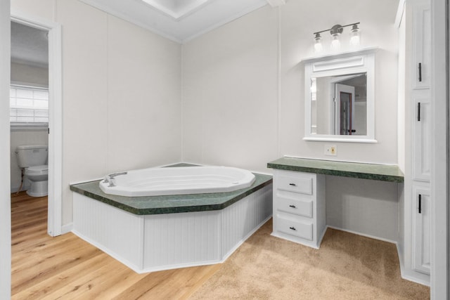 bathroom featuring hardwood / wood-style flooring, vanity, toilet, and a washtub