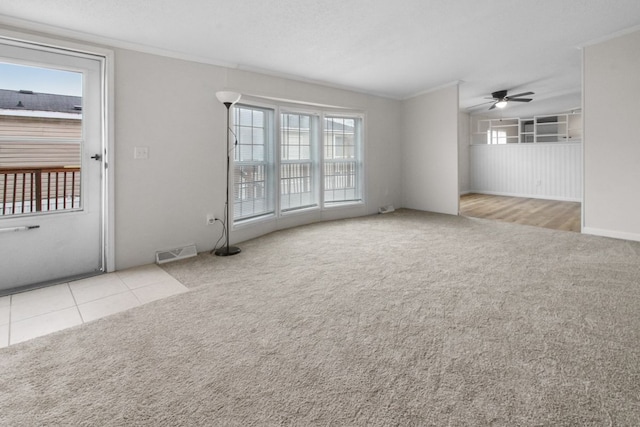 empty room featuring ceiling fan, plenty of natural light, light colored carpet, and a textured ceiling