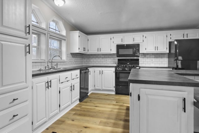 kitchen with white cabinetry, sink, decorative backsplash, and black appliances