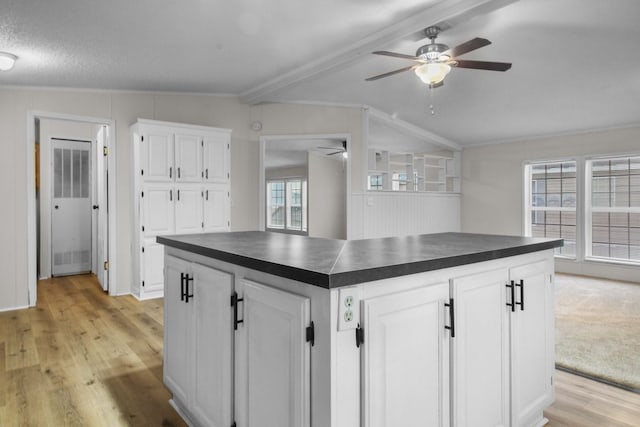 kitchen with white cabinetry, a kitchen island, and light hardwood / wood-style flooring