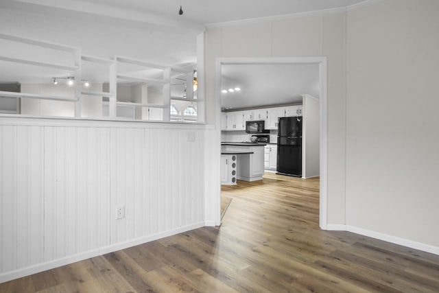 kitchen featuring hardwood / wood-style flooring, ceiling fan, black appliances, white cabinets, and decorative backsplash