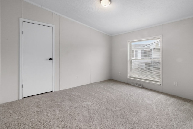 carpeted spare room with a textured ceiling