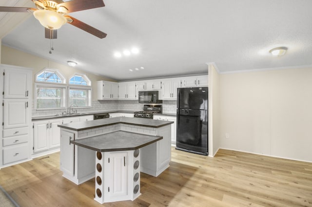 kitchen with white cabinetry, decorative backsplash, black appliances, and a center island