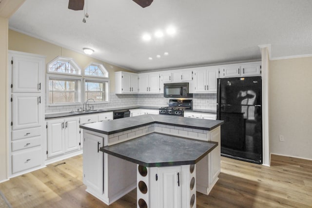 kitchen with sink, black appliances, a center island, and white cabinets