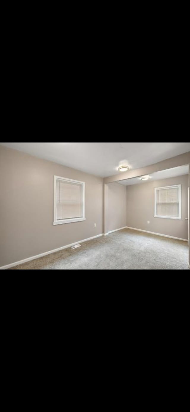 spare room featuring light colored carpet