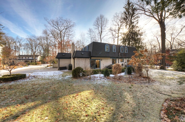 rear view of property featuring a lawn