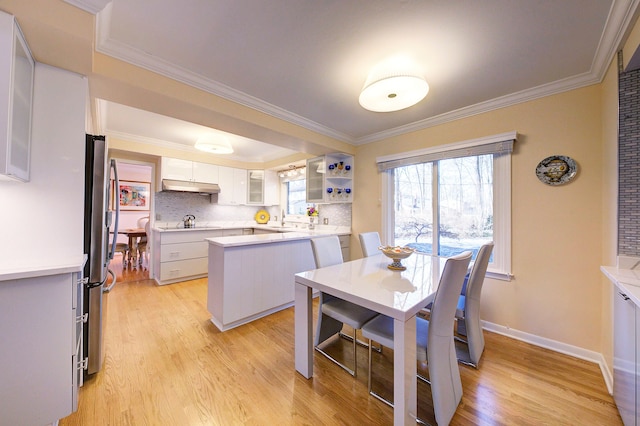 dining space featuring ornamental molding and light wood-type flooring