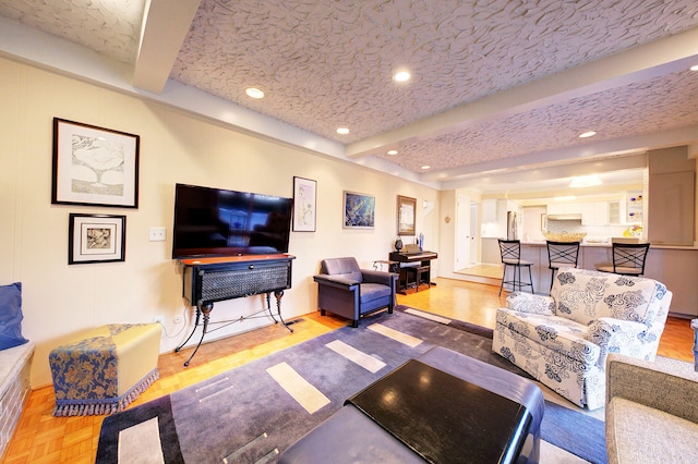 living room with parquet flooring, a textured ceiling, and beam ceiling