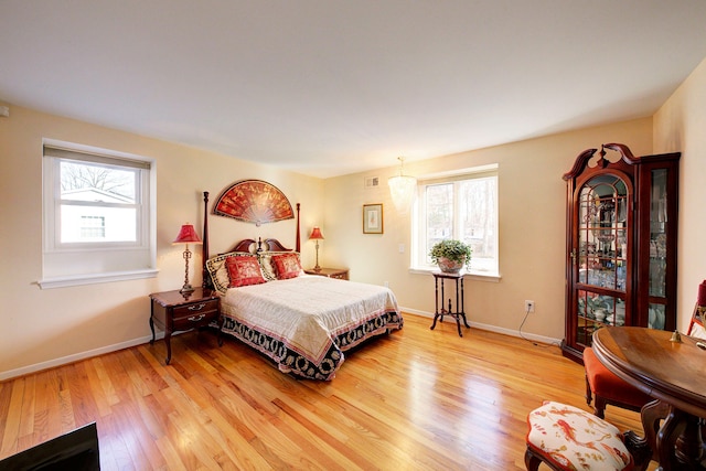 bedroom with hardwood / wood-style floors and multiple windows