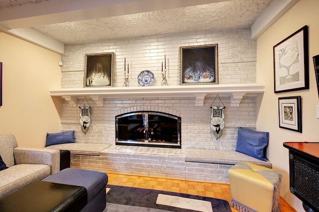 living room with a fireplace, parquet flooring, and a textured ceiling