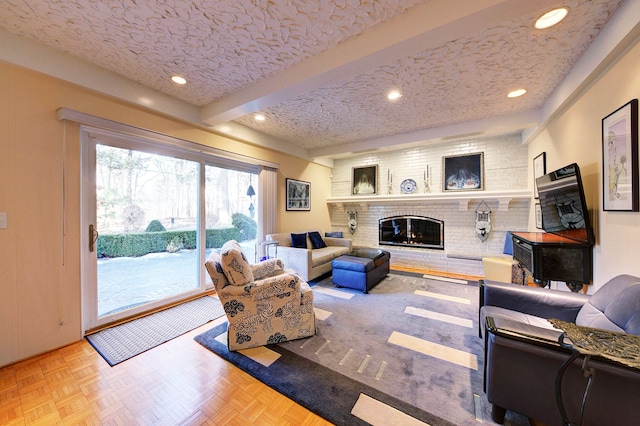 living room featuring parquet floors, a fireplace, a textured ceiling, and beamed ceiling