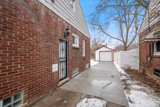 snow covered property with a garage and an outdoor structure