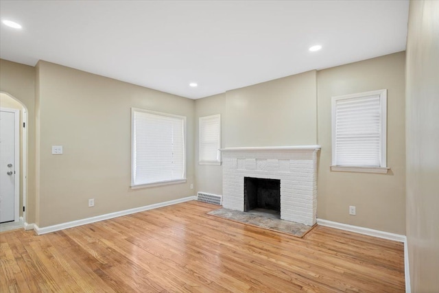 unfurnished living room with a fireplace and light hardwood / wood-style floors