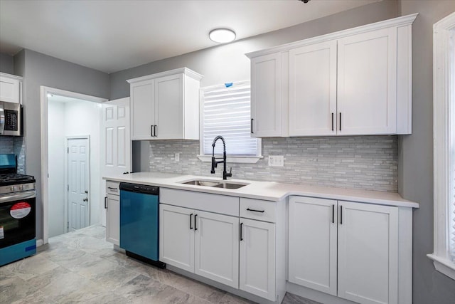 kitchen with appliances with stainless steel finishes, sink, decorative backsplash, and white cabinets