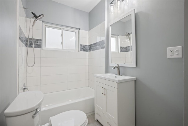 full bathroom with tiled shower / bath combo, vanity, plenty of natural light, and toilet