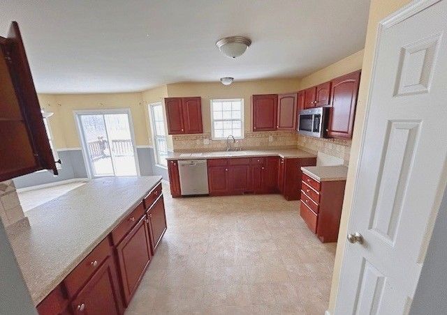 kitchen featuring appliances with stainless steel finishes, sink, and backsplash