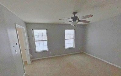 empty room with light colored carpet and ceiling fan