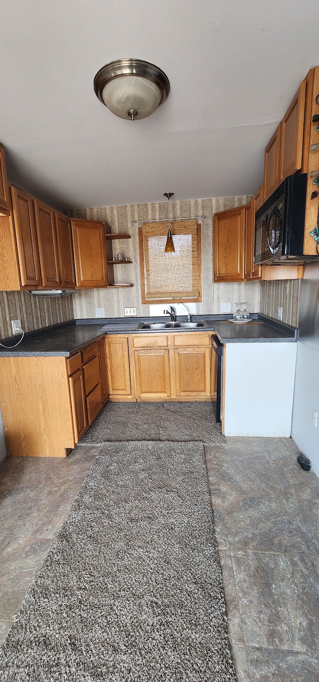 kitchen with hanging light fixtures, sink, and black appliances