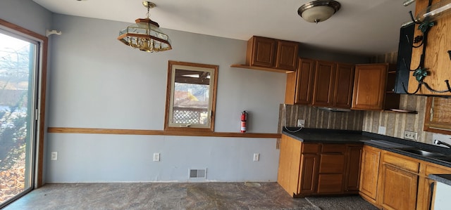 kitchen with hanging light fixtures, sink, and backsplash