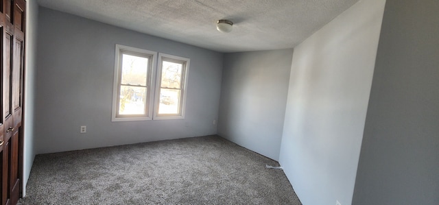 carpeted spare room with a textured ceiling