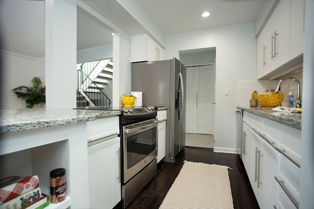 kitchen featuring tasteful backsplash, appliances with stainless steel finishes, dark hardwood / wood-style flooring, light stone countertops, and white cabinets