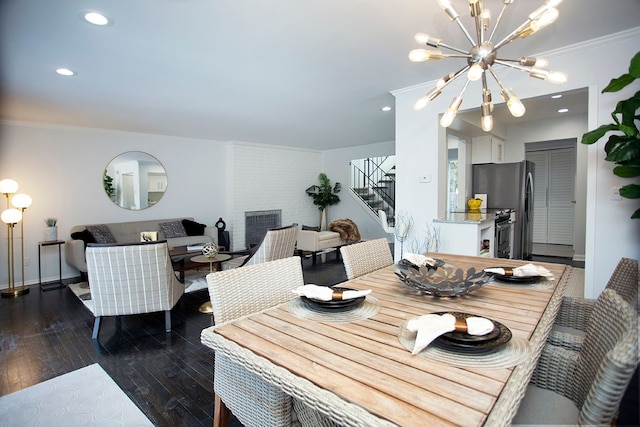 dining area featuring crown molding, dark hardwood / wood-style flooring, and an inviting chandelier