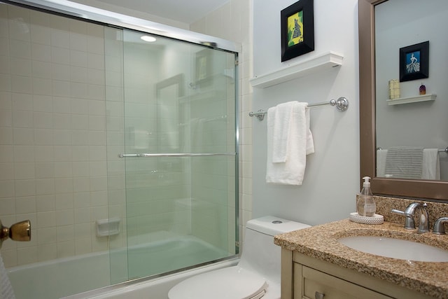 full bathroom with bath / shower combo with glass door, vanity, and toilet