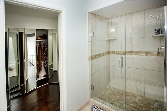 bathroom with hardwood / wood-style flooring and a shower with door