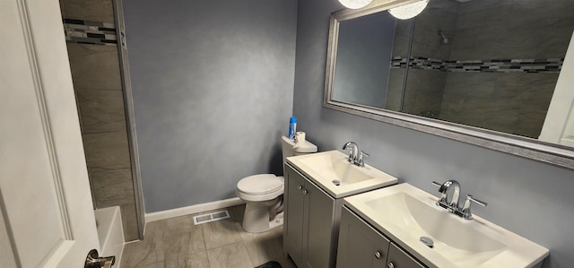 full bathroom with tiled shower / bath, vanity, and toilet