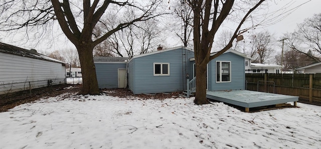 snow covered house with a wooden deck