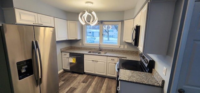 kitchen with white cabinetry, sink, decorative light fixtures, and appliances with stainless steel finishes