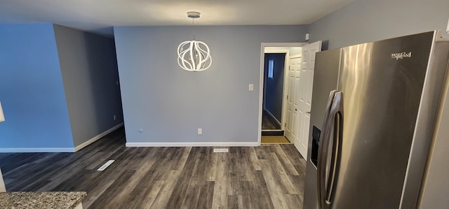 unfurnished dining area with dark hardwood / wood-style floors and a notable chandelier