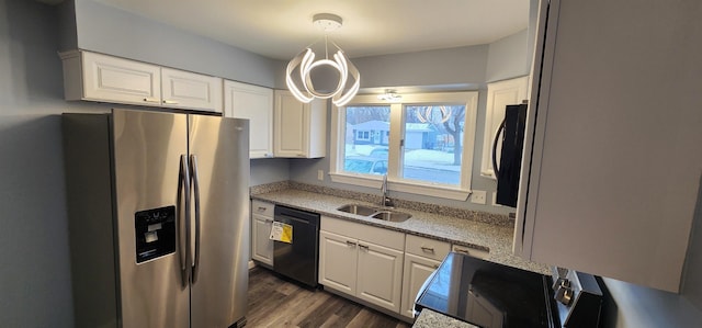 kitchen featuring sink, white cabinetry, hanging light fixtures, stainless steel fridge, and black dishwasher